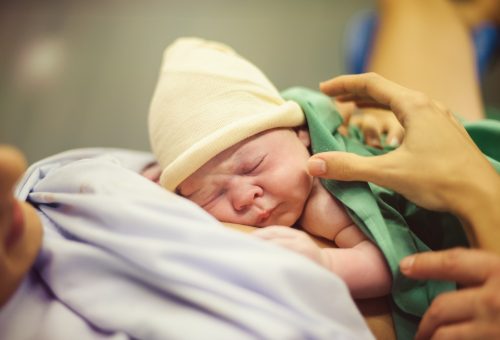 Infant sleeping on faceless mother